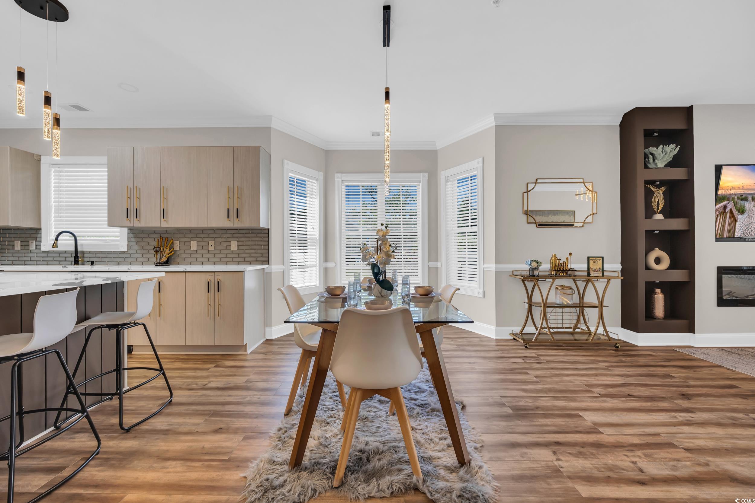 4821 Luster Leaf Circle, Unit 101 Myrtle Beach, SC 29577 - Photo 21 of 30 Dining space featuring light wood-type flooring, crown molding, and built in features