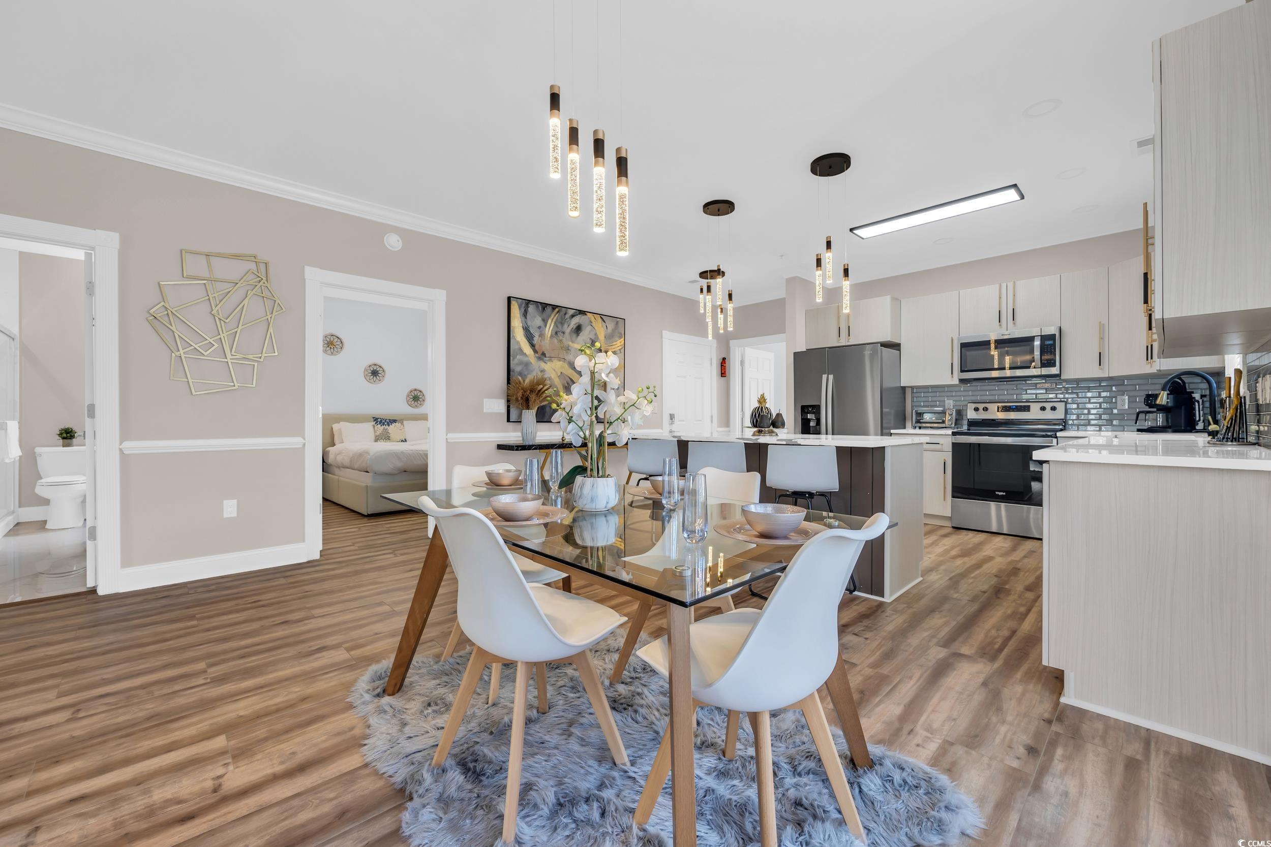 4821 Luster Leaf Circle, Unit 101 Myrtle Beach, SC 29577 - Photo 22 of 30 Dining area with light wood-type flooring and crown molding
