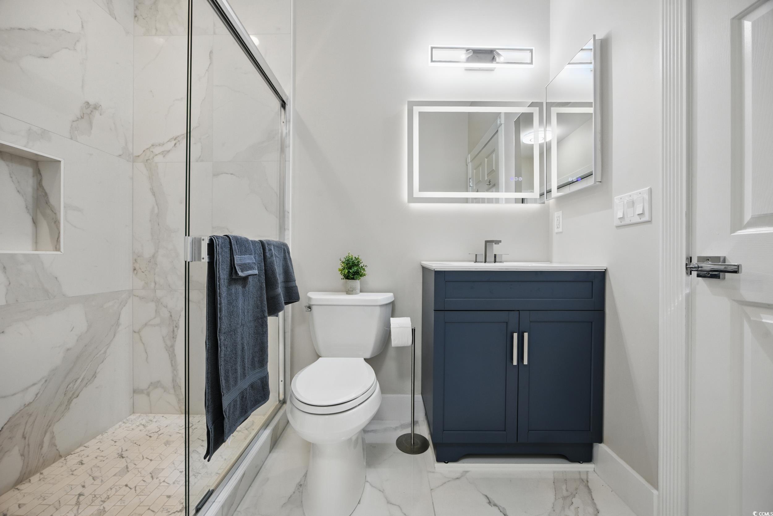 4821 Luster Leaf Circle, Unit 101 Myrtle Beach, SC 29577 - Photo 10 of 30 Bathroom with light marble finish flooring, a marble finish shower, and vanity