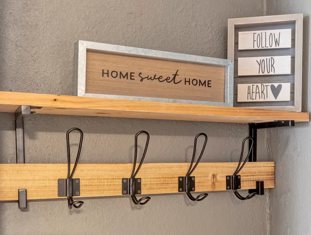 a bedroom with a bed and dresser with wooden floor