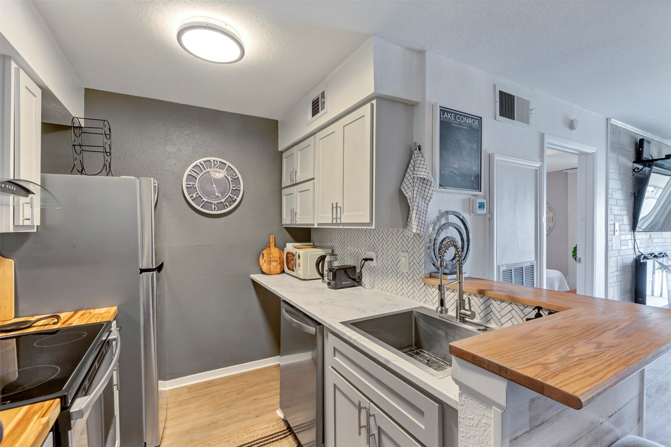 13151 Walden Road, Unit 142 Montgomery, TX 77356 - Photo 7 of 50 a kitchen with granite countertop a sink cabinets and stainless steel appliances