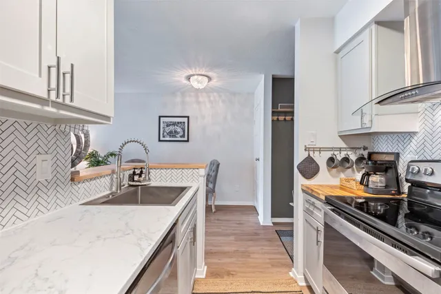 a kitchen with stainless steel appliances granite countertop a sink stove and refrigerator