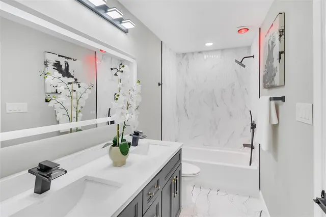 a bathroom with a tub a sink and a shower