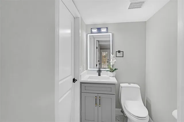 a bathroom with a toilet a sink and mirror