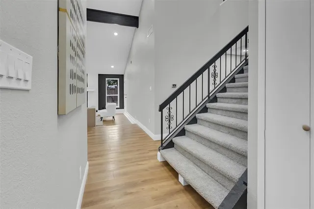 a view of staircase with lots of frames on wall and a window