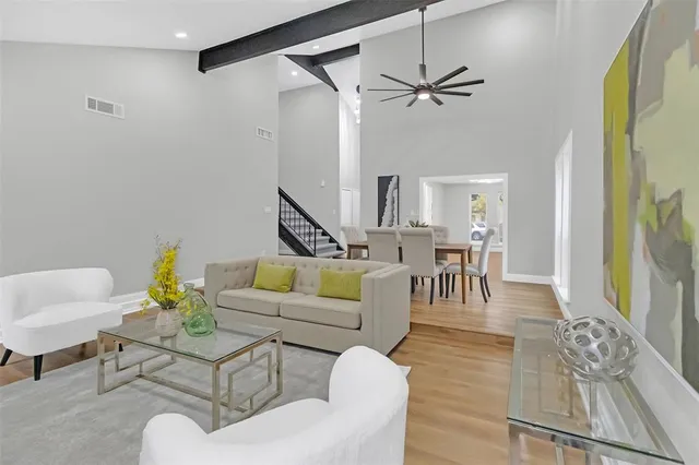a living room with furniture and a dining table with wooden floor