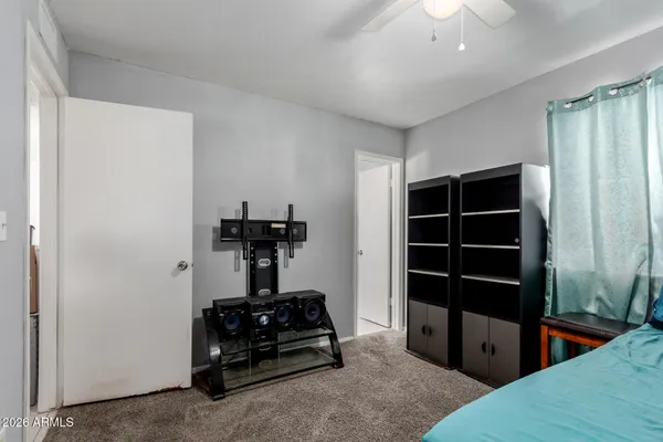 a bedroom with a bed and a chandelier fan