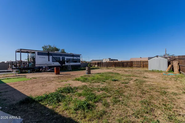 a view of a house with a small yard and wooden fence