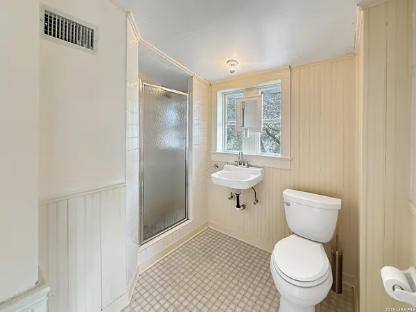 a bathroom with a toilet a window and a shower