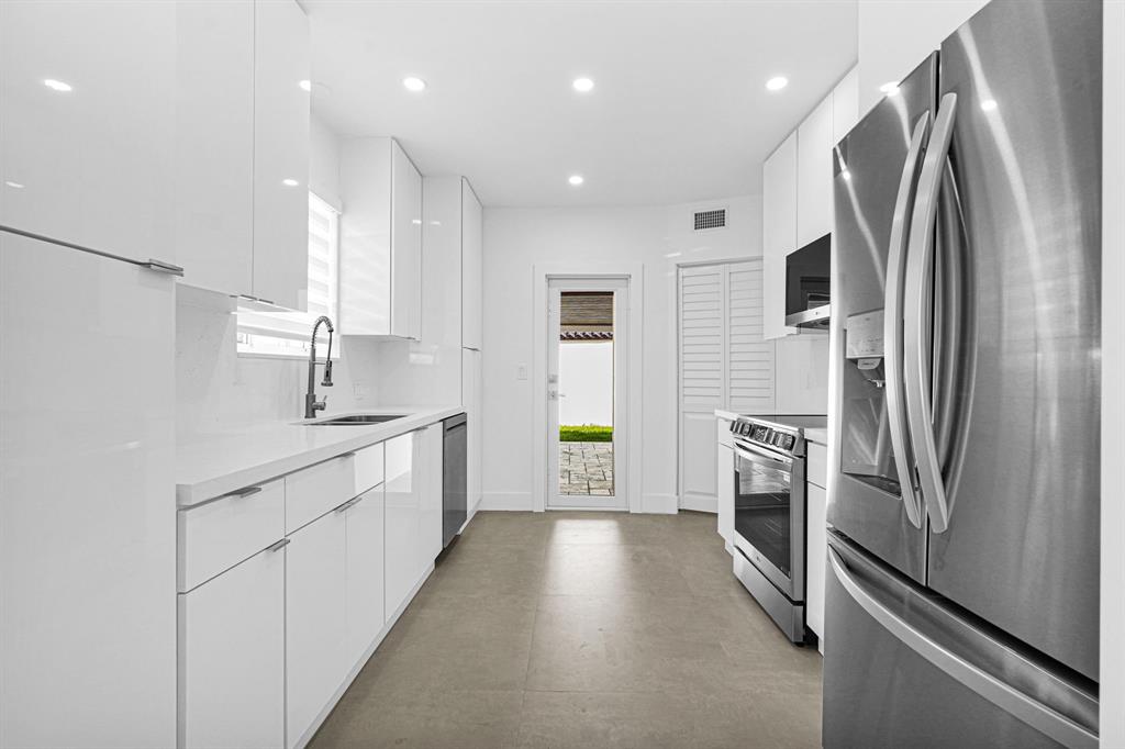 2291 Southwest 17th Street Miami, FL 33145 - Photo 62 of 86 a kitchen with stainless steel appliances a refrigerator sink and white cabinets
