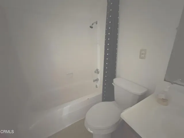 a white toilet sitting next to a bath tub