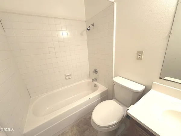 a white toilet sitting next to a bath tub and shower