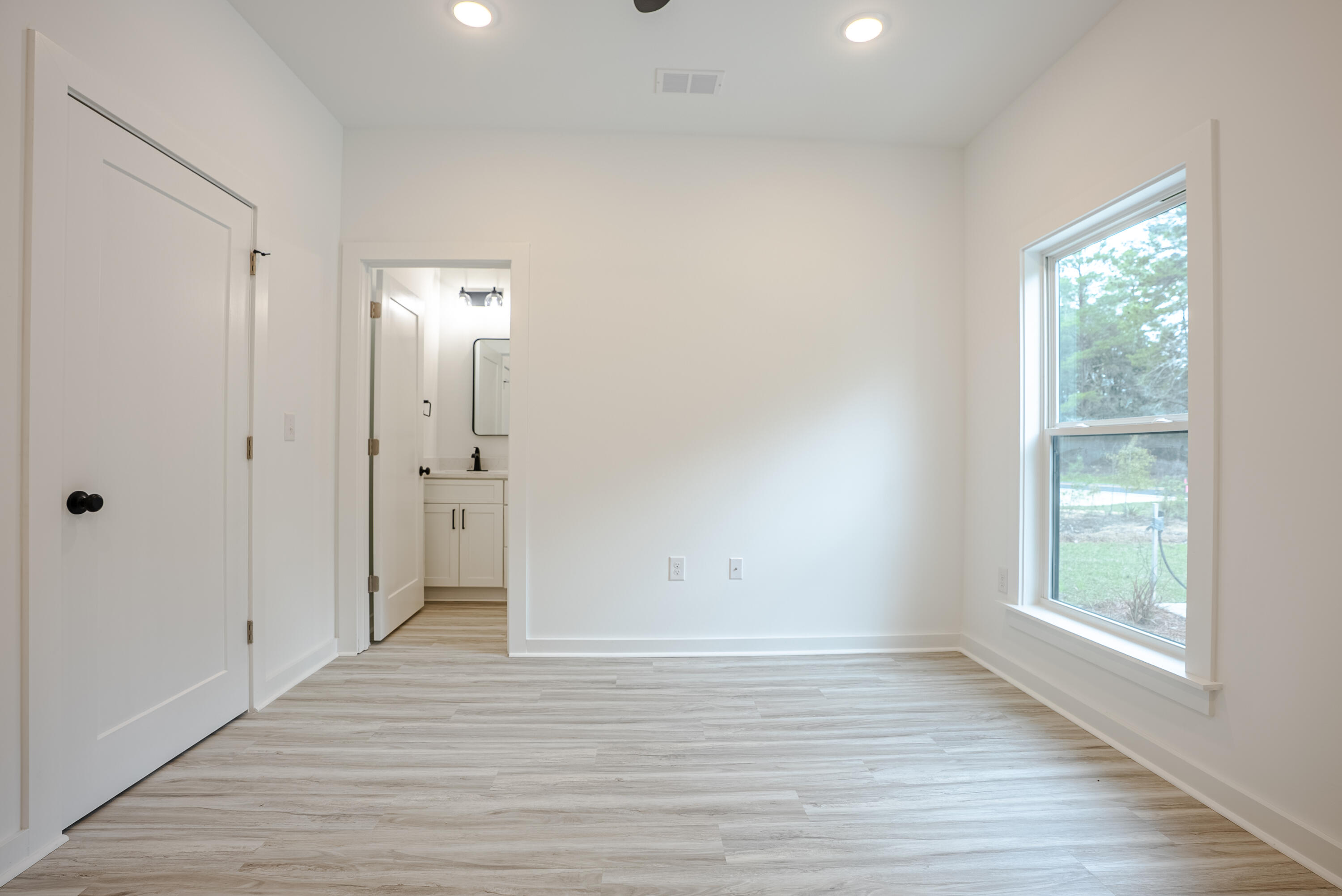 2351 Dumajack Road Chipley, FL 32428 - Photo 13 of 31 an empty room with wooden floor and windows