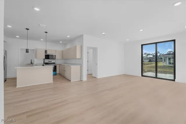 a view of kitchen with kitchen island and stainless steel appliances