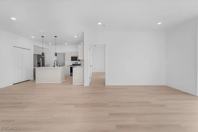 a view of a kitchen with a refrigerator a kitchen island white cabinets and a refrigerator