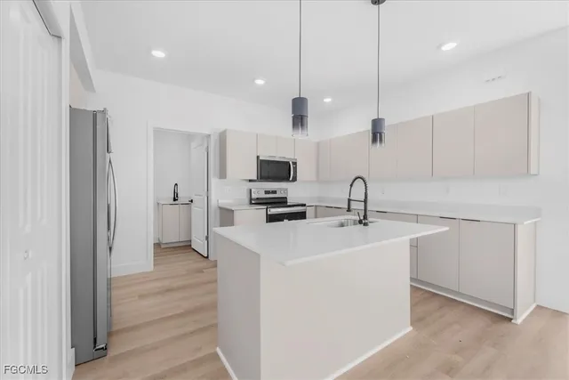 a kitchen with white cabinets appliances and sink