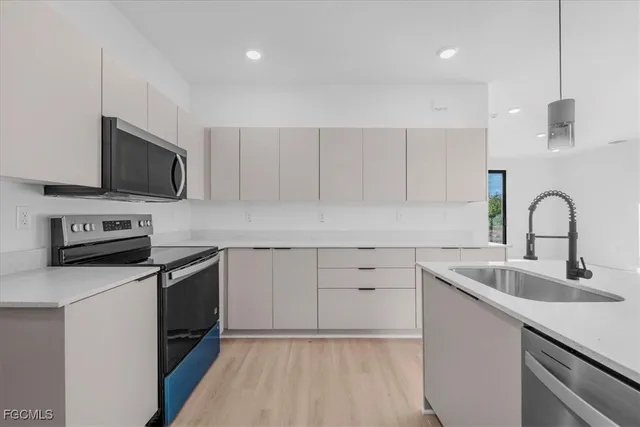 a kitchen with cabinets stainless steel appliances and a sink