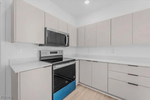 a kitchen with cabinets stainless steel appliances and a counter space