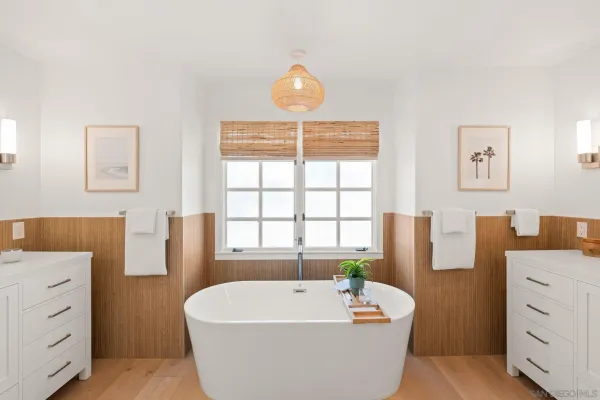 a spacious bathroom with a tub shower and mirror