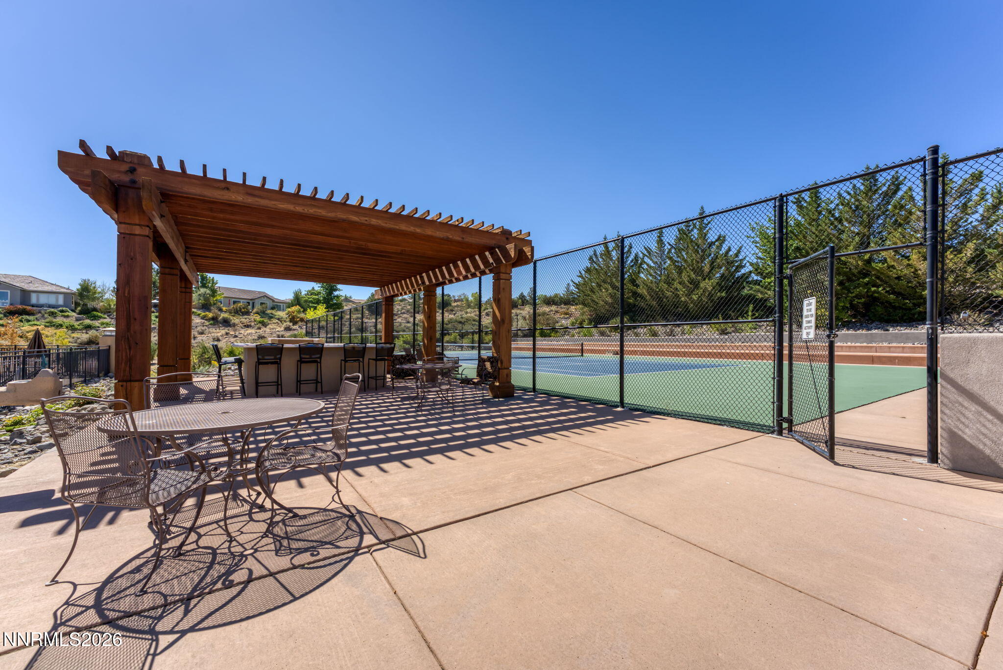 10170 Vía Como Reno, NV 89511 - Photo 73 of 85 a view of a patio with a table and chairs under an umbrella with large trees
