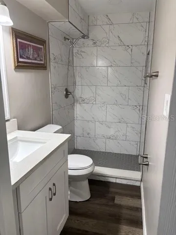 a bathroom with a sink a toilet and shower