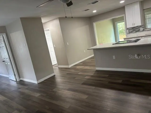 an empty room with wooden floor and entrance