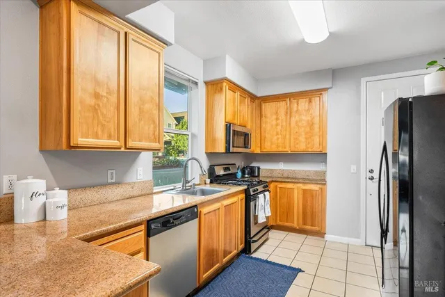 a kitchen with stainless steel appliances granite countertop a stove a sink and a refrigerator