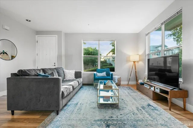 a living room with furniture a flat screen tv and a large window