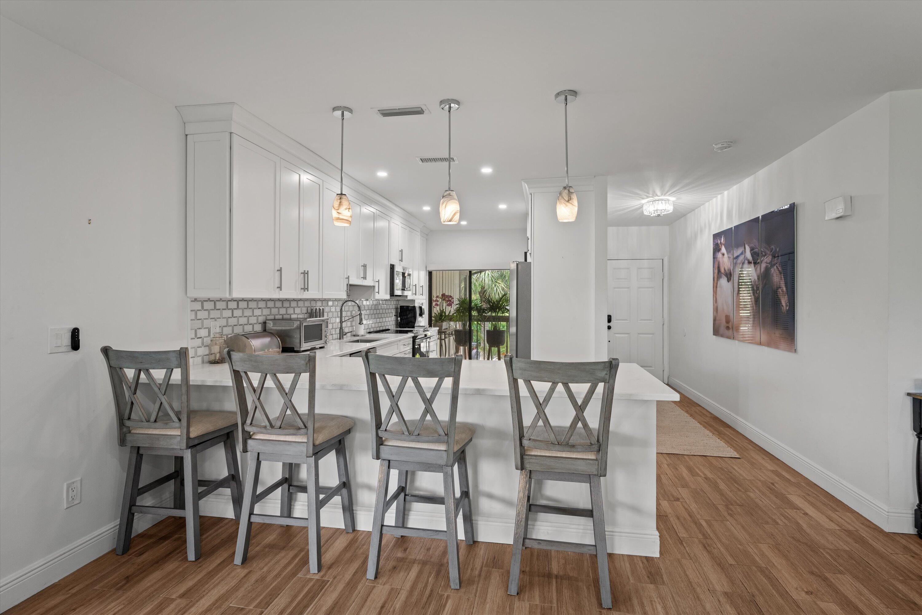 13400 Polo Road West, Unit 203 Wellington, FL 33414 - Photo 9 of 26 a view of a dining room with furniture and wooden floor