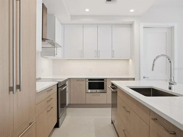 a view of a kitchen with a sink and white cabinets