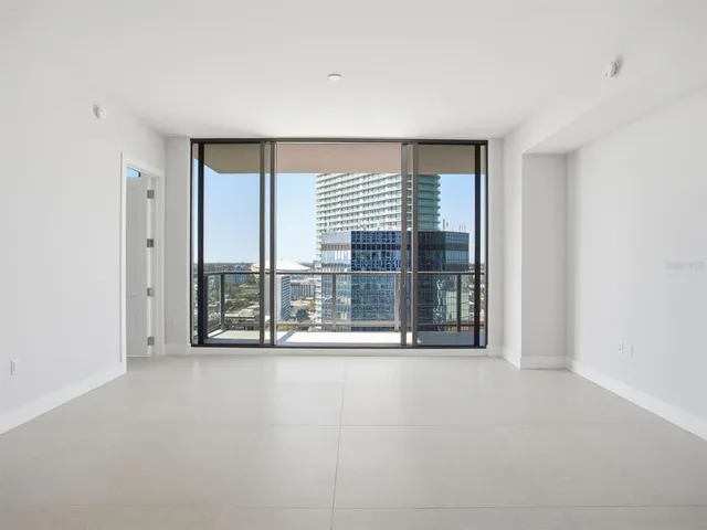 a dining room with furniture a large window and a chandelier
