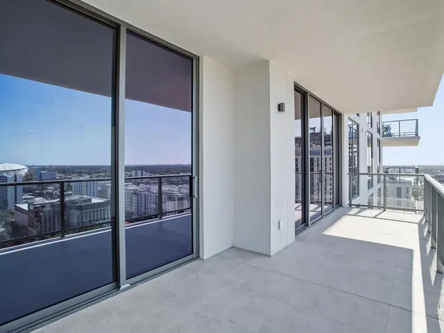 a very nice looking living room with a large window and dining table