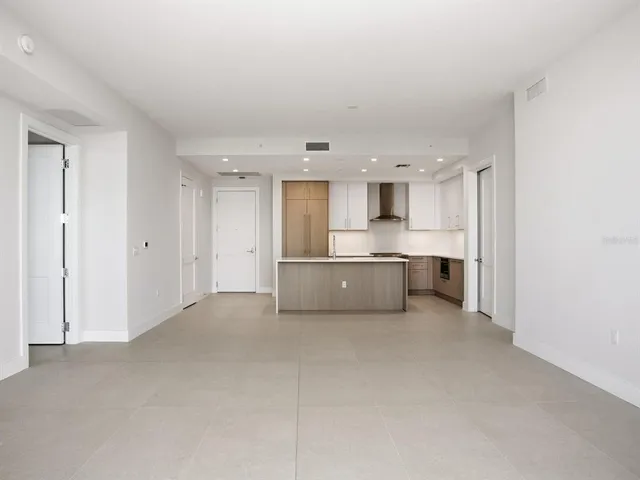 a room with a table chairs and a refrigerator