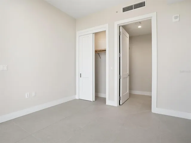 a front view of a building with swimming pool and outdoor seating
