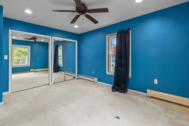 an empty room with closet and a chandelier fan