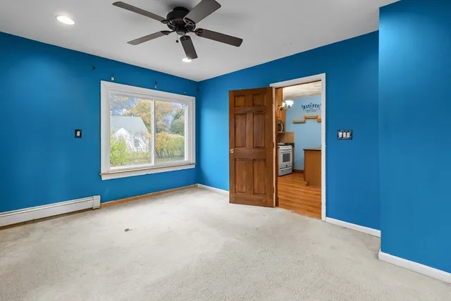 an empty room with windows and ceiling fan
