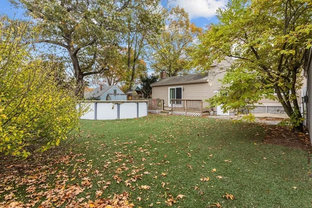 a view of a house with backyard and a tree