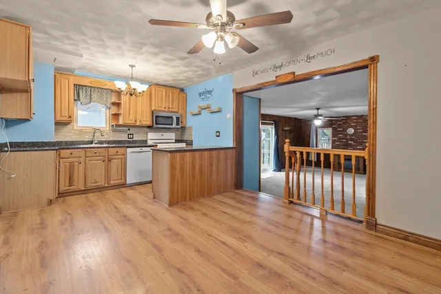 a large kitchen with wooden floor and stainless steel appliances