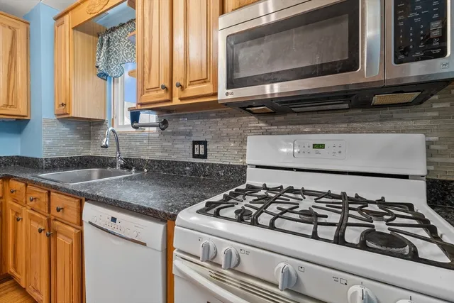 a kitchen with stainless steel appliances granite countertop a sink stove and microwave