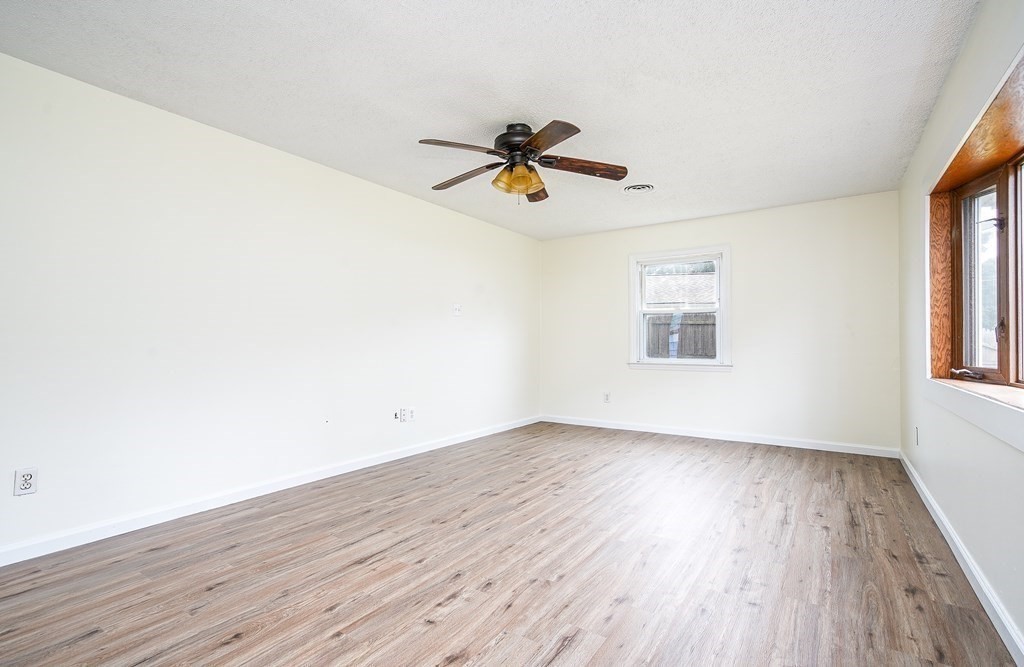 81 Pembroke Circle Springfield, MA 01104 - Photo 3 of 14 an empty room with wooden floor ceiling fan and windows