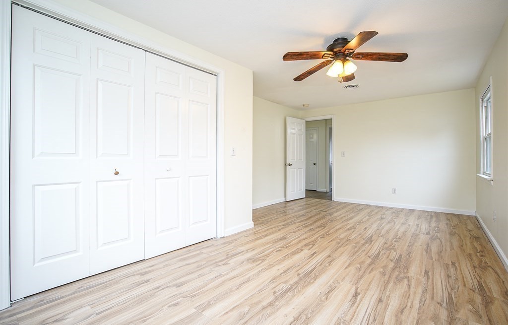 81 Pembroke Circle Springfield, MA 01104 - Photo 4 of 14 an empty room with wooden floor chandelier fan and windows