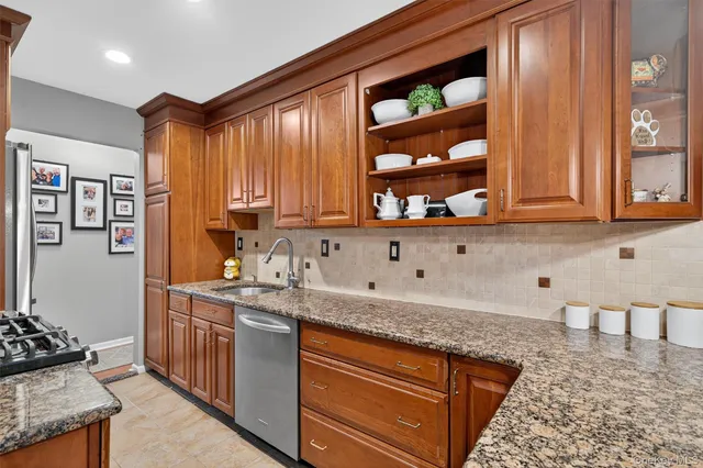a kitchen with stainless steel appliances granite countertop a sink stove and cabinets
