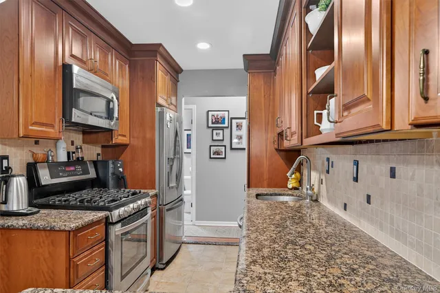 a kitchen with stainless steel appliances granite countertop a stove and a refrigerator