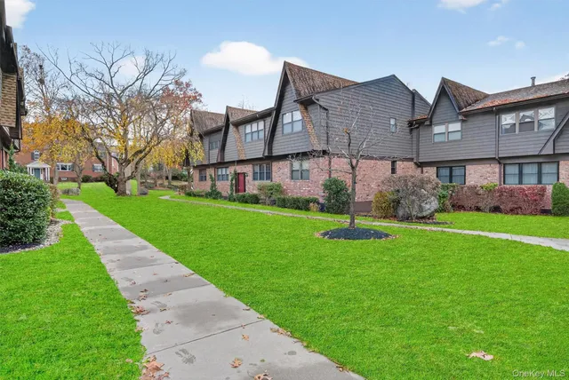 a view of a house next to a yard with big trees
