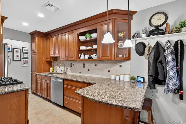 a kitchen with stainless steel appliances granite countertop a sink dishwasher stove and cabinets