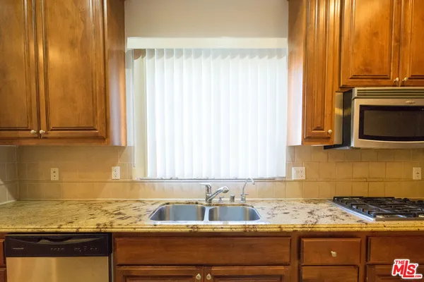 a kitchen with granite countertop a sink and a stove top oven