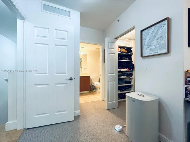 a view of a hallway with wooden cabinets and a window