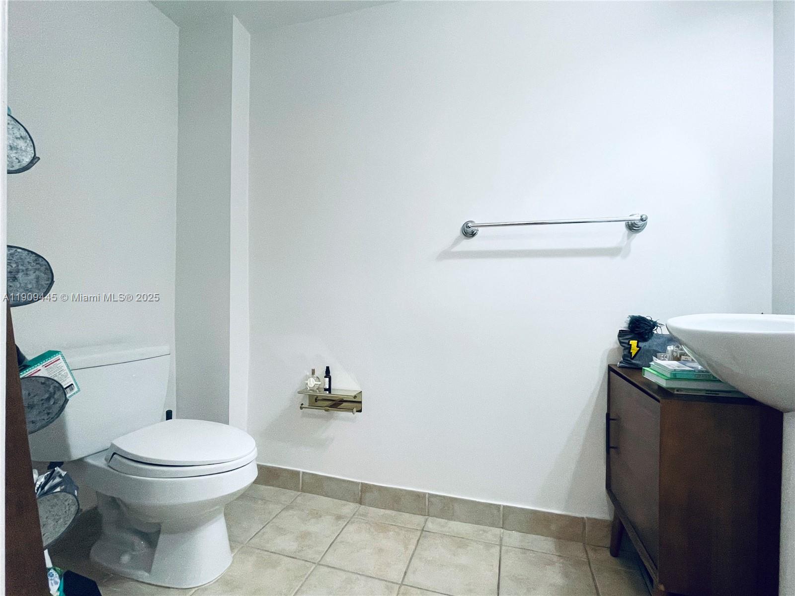 888 Douglas Road, Unit 119 Coral Gables, FL 33134 - Photo 29 of 36 a bathroom with a toilet and a rug