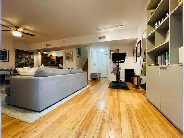 a living room with stainless steel appliances kitchen island lots of furniture and chandelier