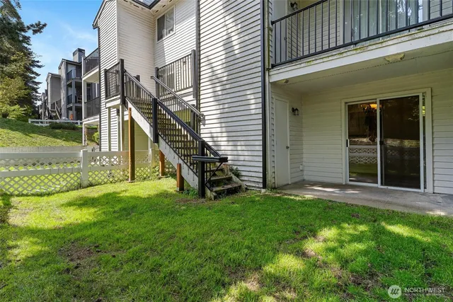 a view of a wooden house with a fence and a yard